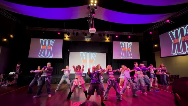 K-Pop dance crew mid-formation on stage