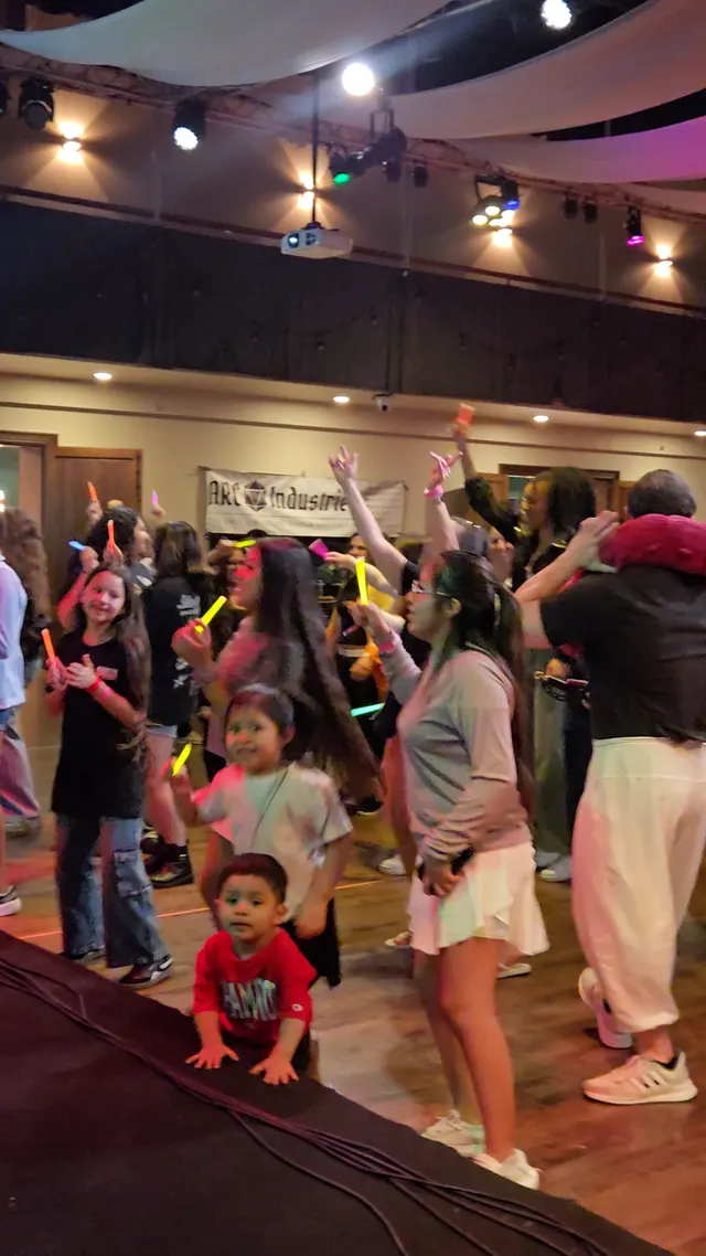 crowd with glow sticks dancing on open floor